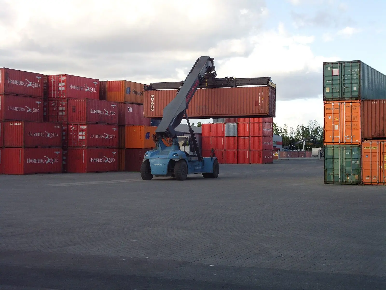 A reach stacker moving containers in a terminal yard